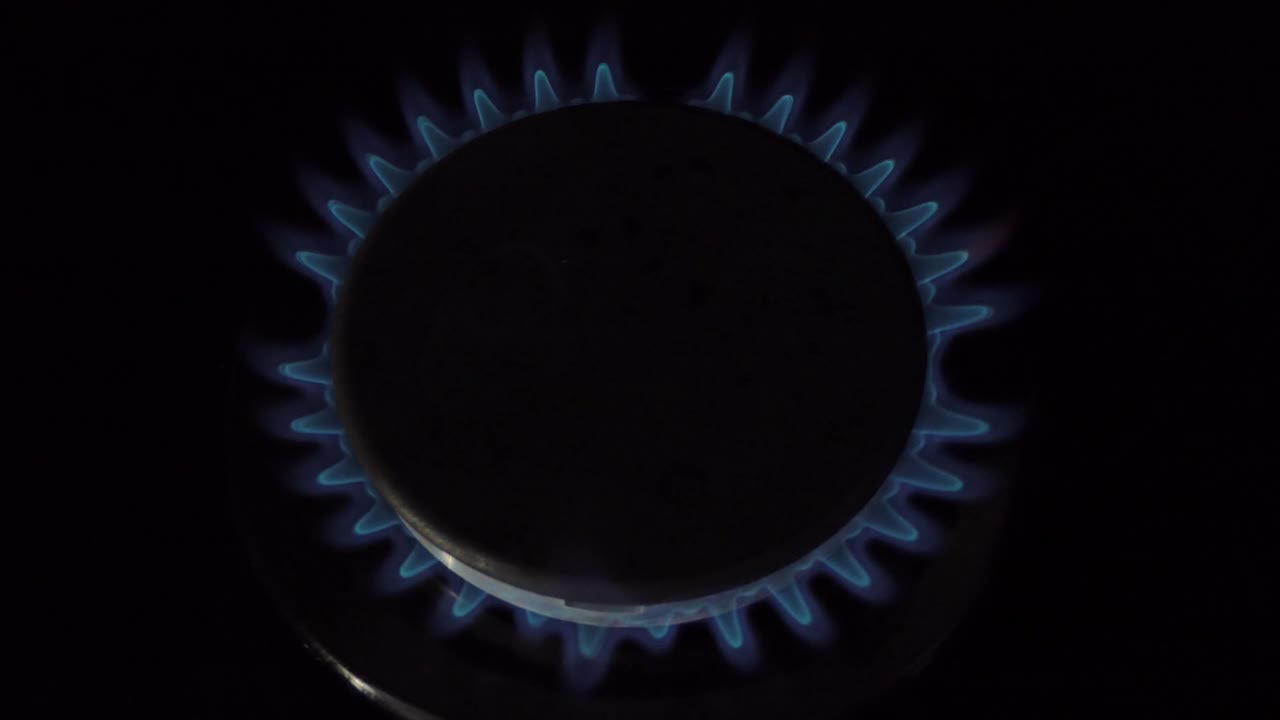 가스 스토브는 켜진 버너에 의해 켜지고 있습니다. 천연 가스 개념.