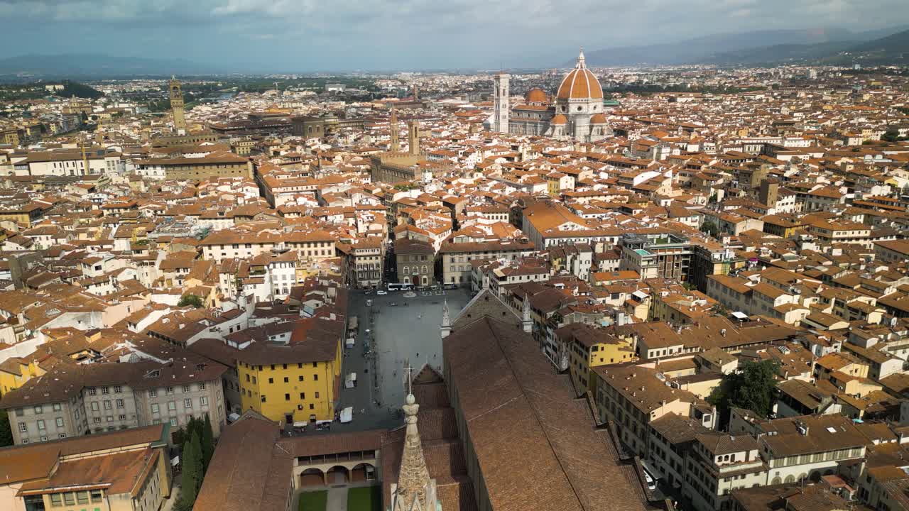 Ripresa aerea all'indietro sopra la Basilica di Santa Croce a Firenze, Italia, mentre un'ombra di nuvola passa sopra l'edificio
