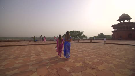 two women in saris walking away