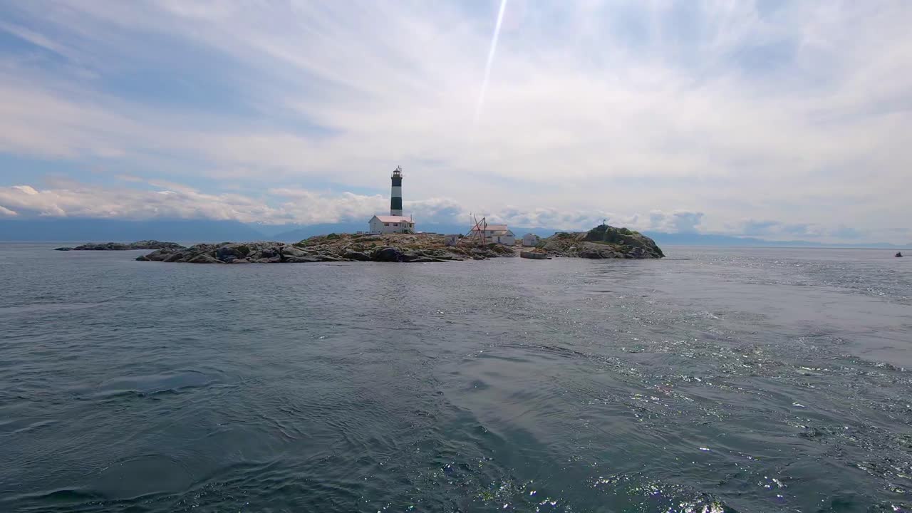 vista del faro de las islas de prueba desde el barco en movimiento en victoria, columbia británica, canadá