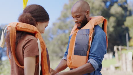 Kayak,-lifejacket-and-couple-high-five-by-lake