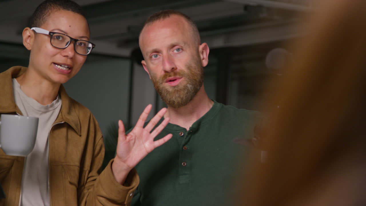 Female Film Director Talking With Male Camera Operator Shooting Movie Or Video In Studio Shot In Real Time