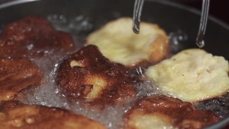 golden brown rabanadas being turned to fry on each side - close up