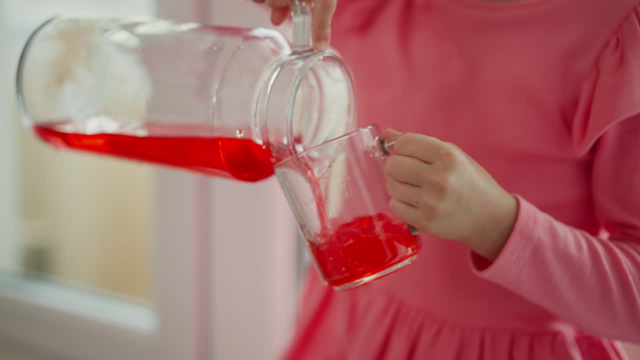 Child pouring juice into a glass