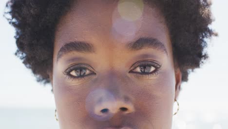 video of face of happy african american woman looking at camera on beach