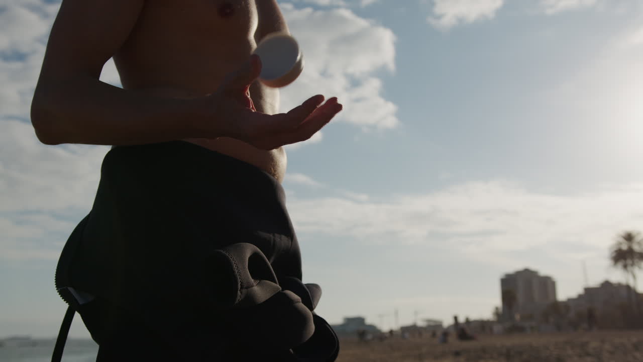 Surfer man walking to the beach at sunset preparing for surfing training and search for waves in Barcelona, spain, water, ocean exercise in sea with board, athletic male holiday or travel in vacation