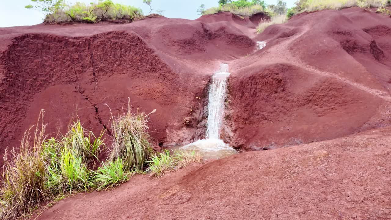 The famous Red Dirt Falls, a cascading waterfall of fresh water over the iron-rich basalt rock in Waimea Canyon State Park, located on the west side of the island of Kauai, Hawaii, United States.