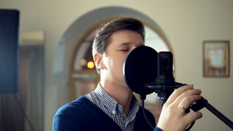 a man sings into a studio microphone