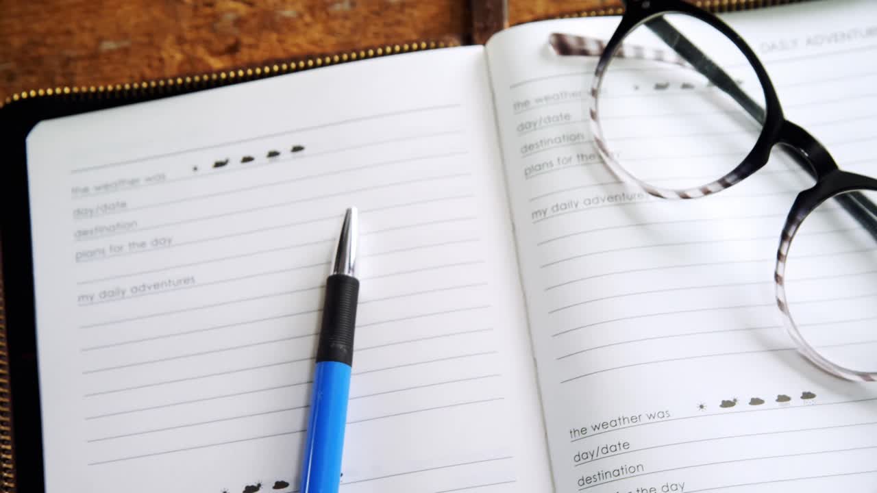 Spectacles and pen on organizer at desk 4k