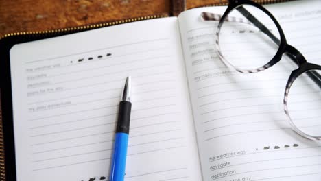 gafas y bolígrafo en el organizador en el escritorio 4k