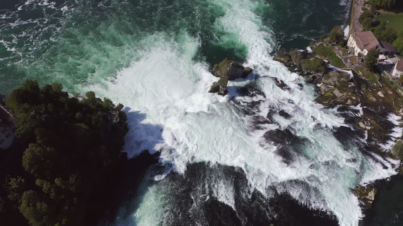 cámara lenta: toma aérea reveladora que comienza en el ojo de pájaro y luego gira para mostrar el área alrededor del rheinfall en suiza