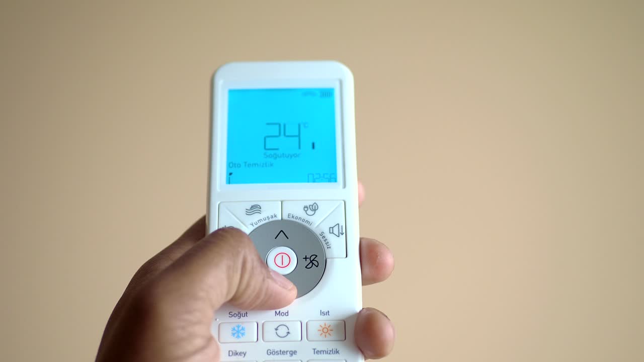 mano usando un control remoto del aire acondicionado