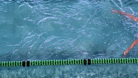 mujer en forma haciendo el golpe de pecho en la piscina