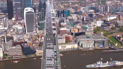 Aerial-view-from-the-City-of-London,-past-the-Shard-and-River-Thames-to-Tower-Bridge-with-the-Isle-of-Doge-behind