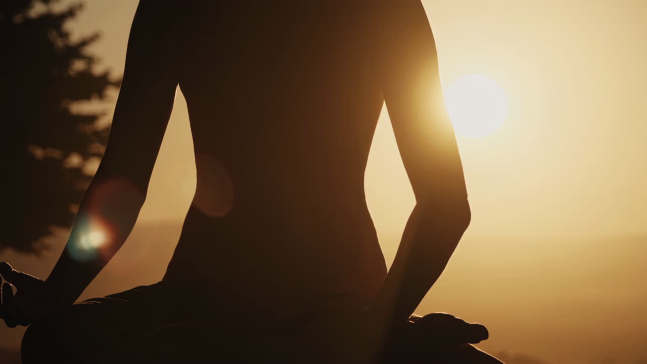 Mujer en postura de yoga al atardecer