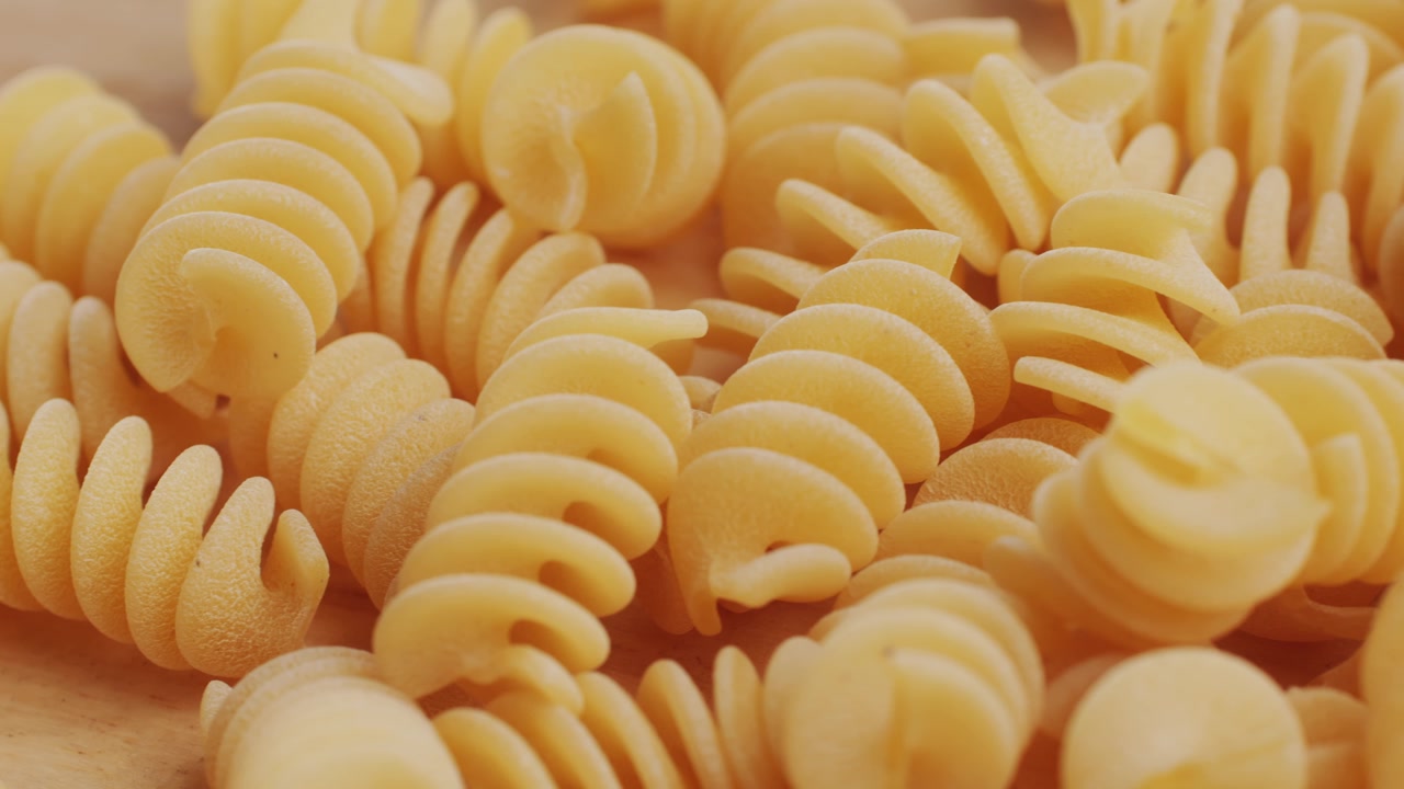 Scatto macro di fusilli crudi su sfondo di legno