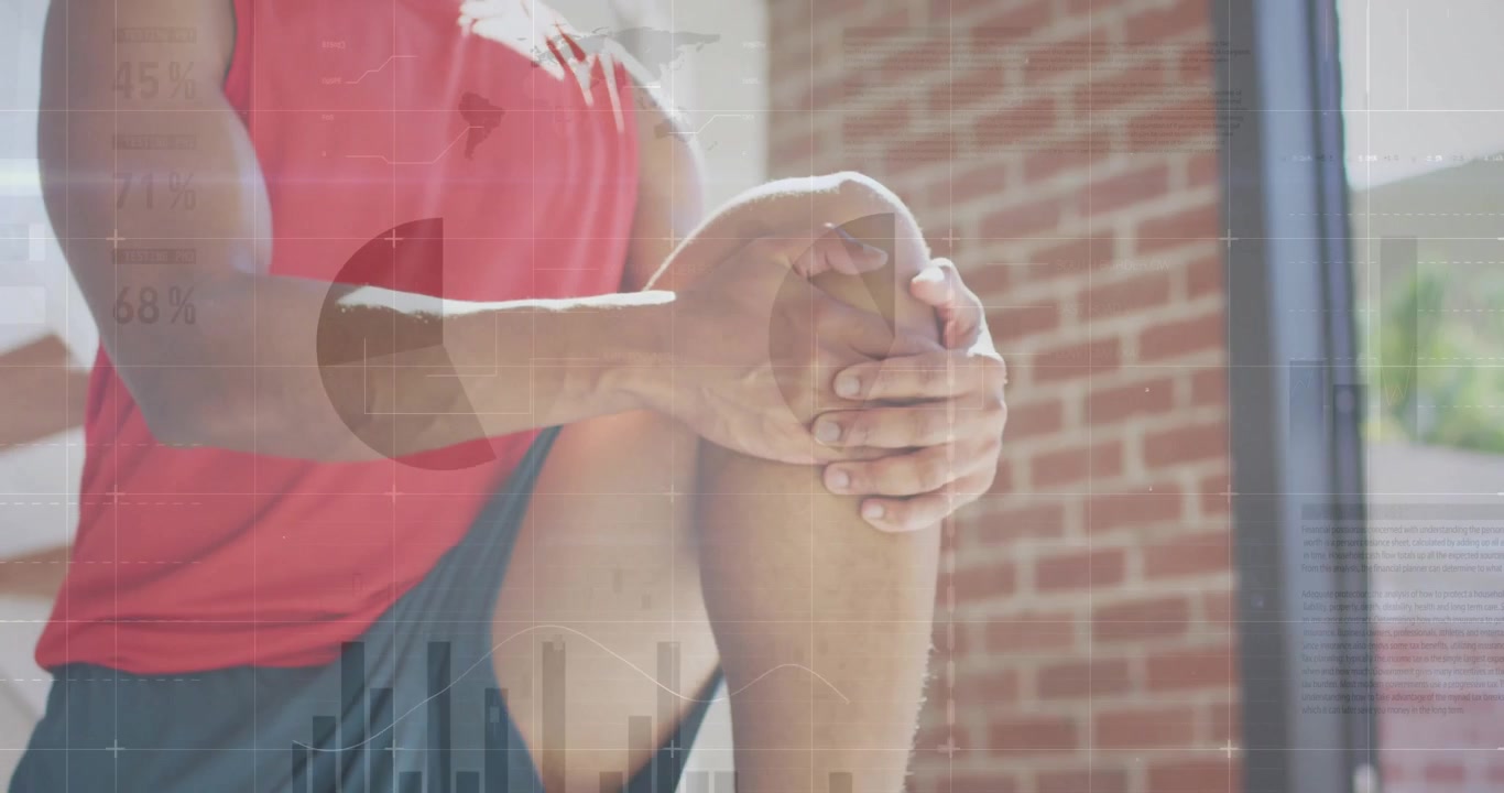 Appassionato di fitness che solleva una gamba e tira lo stinco in uno stretching ginocchio-al-petto accanto a una finestra di mattoni.