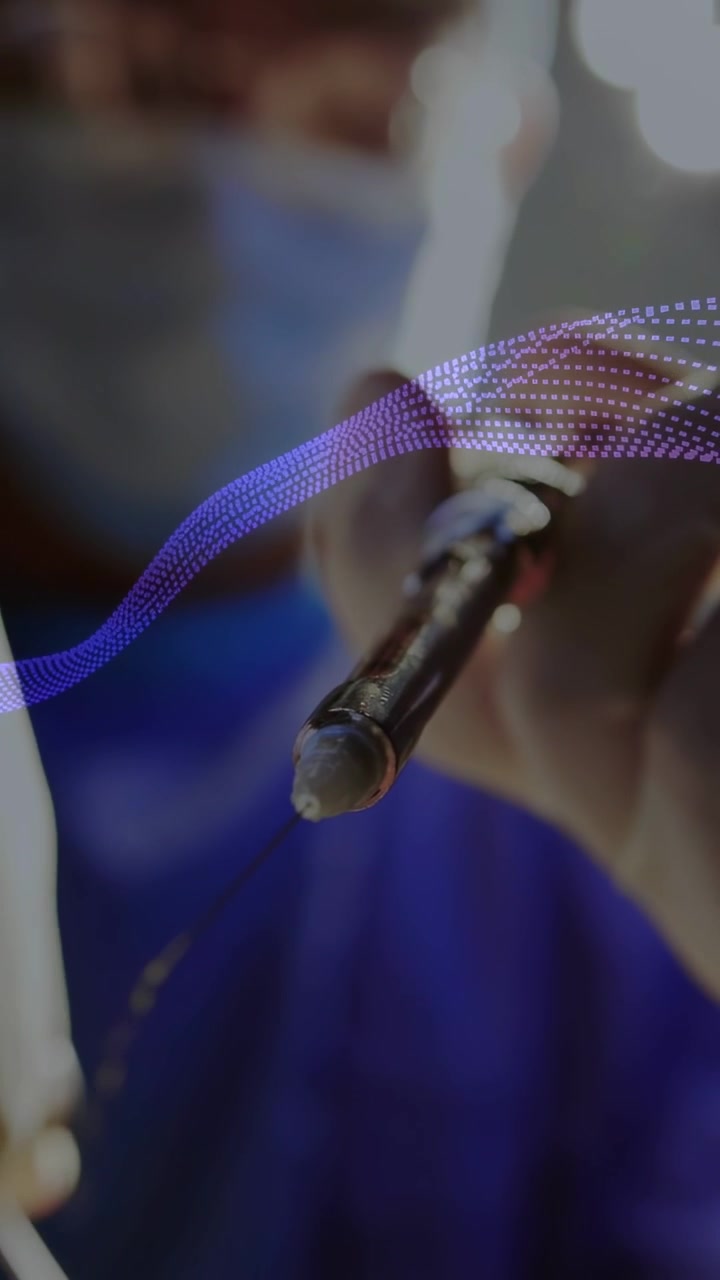 Vertical video: Clinician heating tip for surgery, bead forming as dotted wave passes over tip