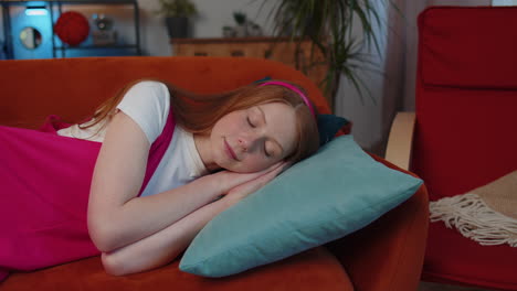 una niña cansada, una niña acostada en la cama, descansando en casa, durmiendo, quedándose dormida en el sofá.