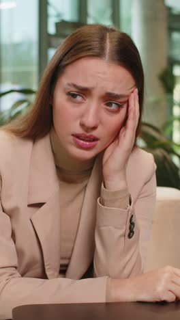depressed desperate young businesswoman feeling worried about financial problems in office lobby