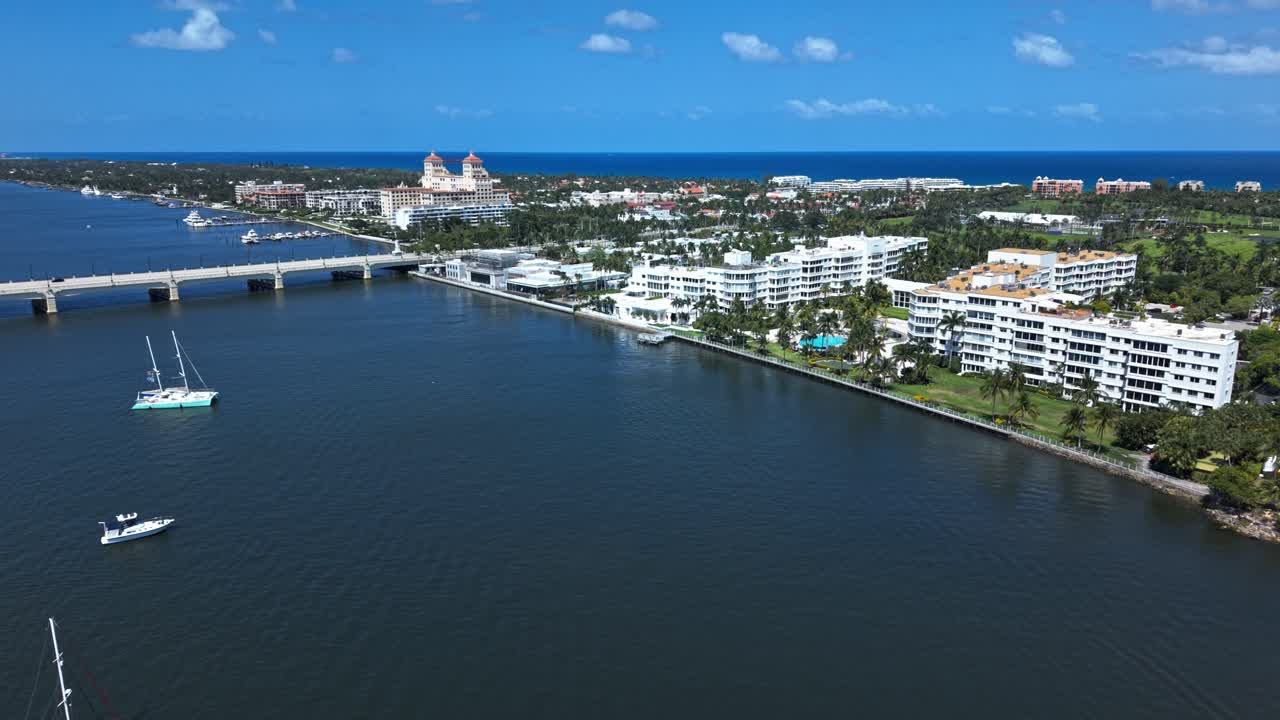Aerial: downtown West Palm Beach cityscape with palm trees and a bridge during the day in Florida, USA, push in drone shot
