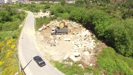 excavator removing sand into dump truck aerial view