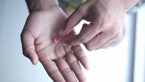 persona sosteniendo una píldora rosa en la mano