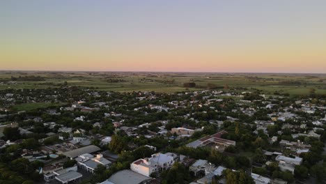 Dolly-out-flying-over-Santa-Elisa-countryside-town-houses-surrounded-by-trees-and-farmlands-in-background,-Entre-Rios,-Argentina