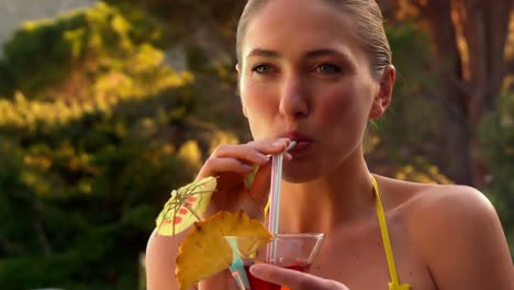 Sexy-blonde-drinking-cocktail-in-yellow-bikini