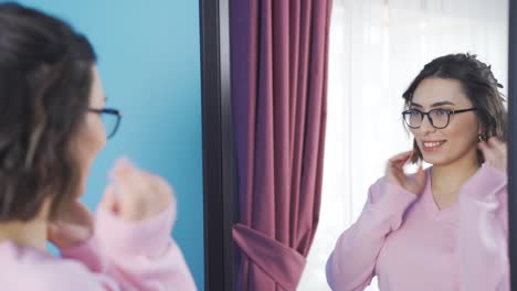 happy young woman looking at herself in the mirror.