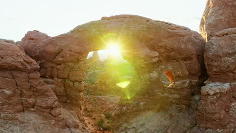 bright sun shining through the hole of double arch in arches natural park, utah, united states