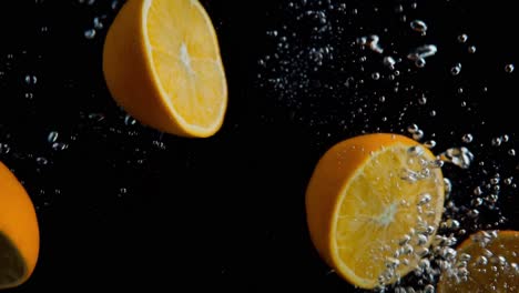 naranjas cayendo al agua en cámara superlenta, fondo negro, muchas burbujas de aire, 4k240fps