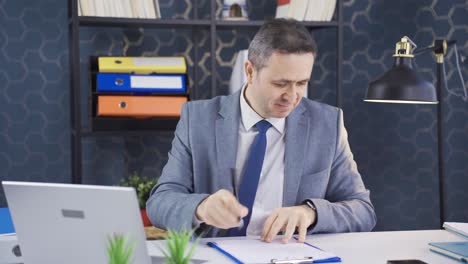 Happy-businessman-working-on-laptop-in-his-office.