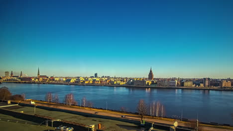 Timelapse-of-clouds-passing-over-Daugava-river-in-Riga-city-with-skyline-in-background,-Latvia