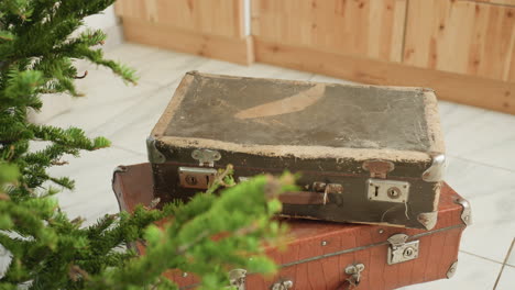 close-up view of three boxes stacked beside festive tree in cozy home setting, capturing holiday spirit, vintage storage boxes placed near christmas tree, winter season decorations
