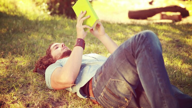 Giovane uomo che legge un libro al parco, in alta qualità 4K