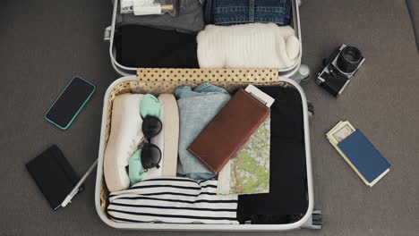 Open suitcase with packed travel items