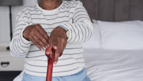 Mid-section-of-senior-african-american-woman-with-walking-stick,-copy-space,-slow-motion