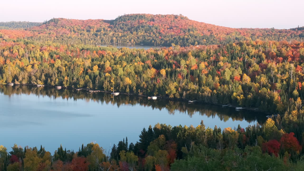 panorámica lenta de pintorescas cabañas en el lago con colores otoñales