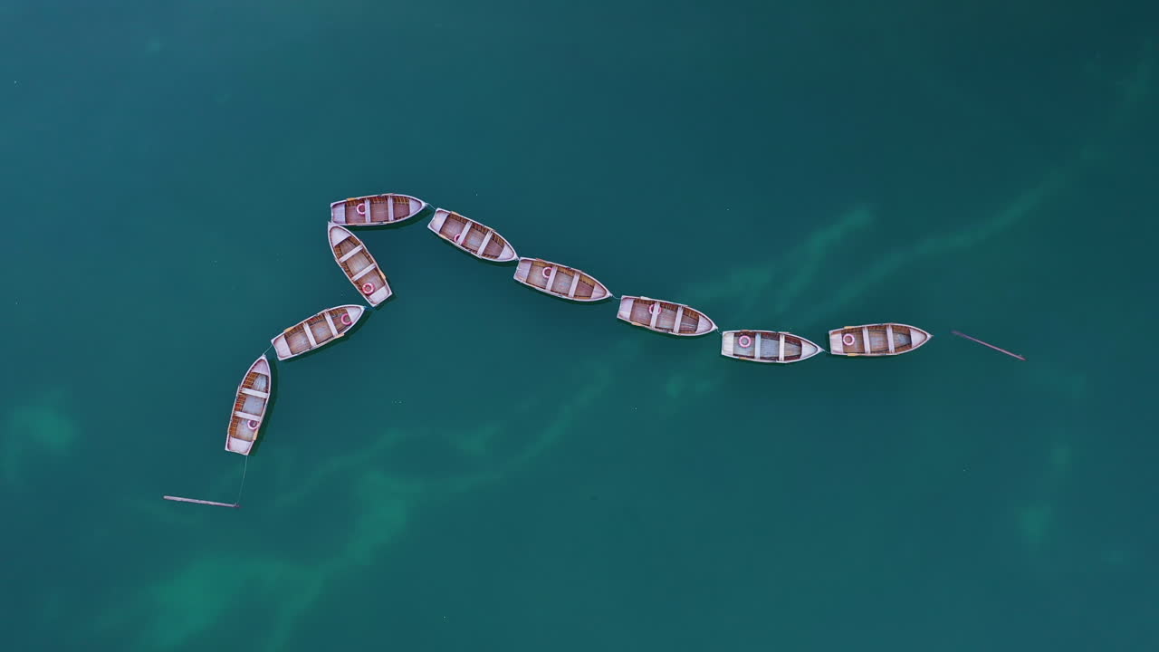 이탈리아 남부 티롤(south tyrol italy)의 아름다운 라고 디 브라이에스(lago di braies), 이탈리아 돌로미테(dolomites)에 묶인 나무 보트의 영화 같은 하향 각도 드론 샷