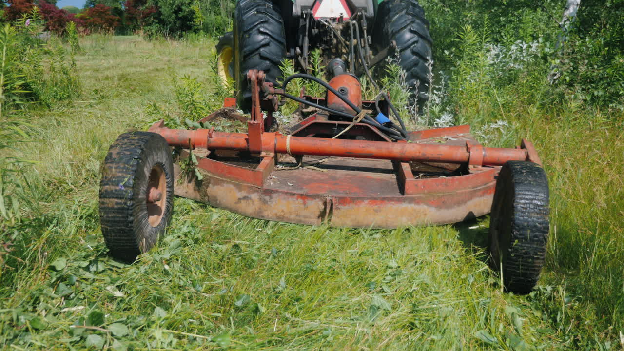 트랙터가 풀을 깎는 장치를 당깁니다