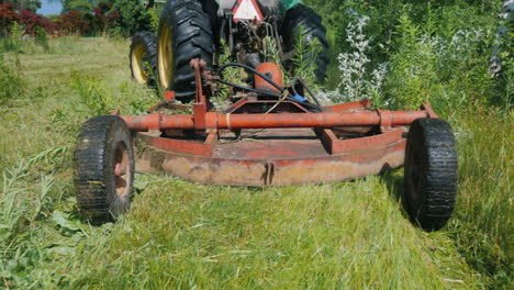 el tractor tira de la segadora de hierba