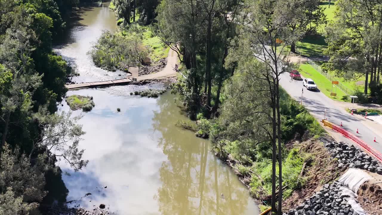 Aerial footage of a river winding through lush forests, showcasing natural beauty and tranquility