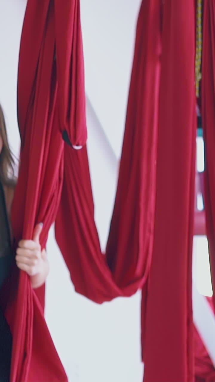 gorgeous woman has fun sitting in hammock and swinging after anti-gravity yoga workout close view slow motion