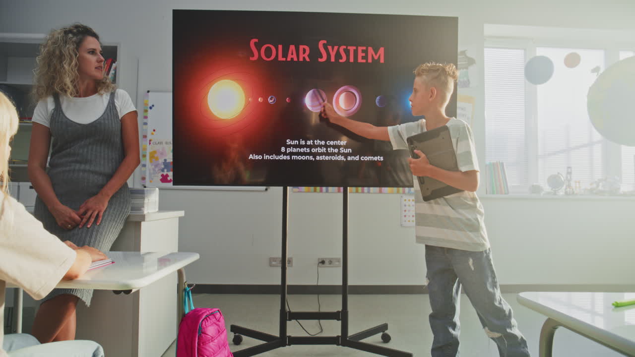 Elementary School Boy Giving Presentation About Solar System and Planets Using Digital Screen