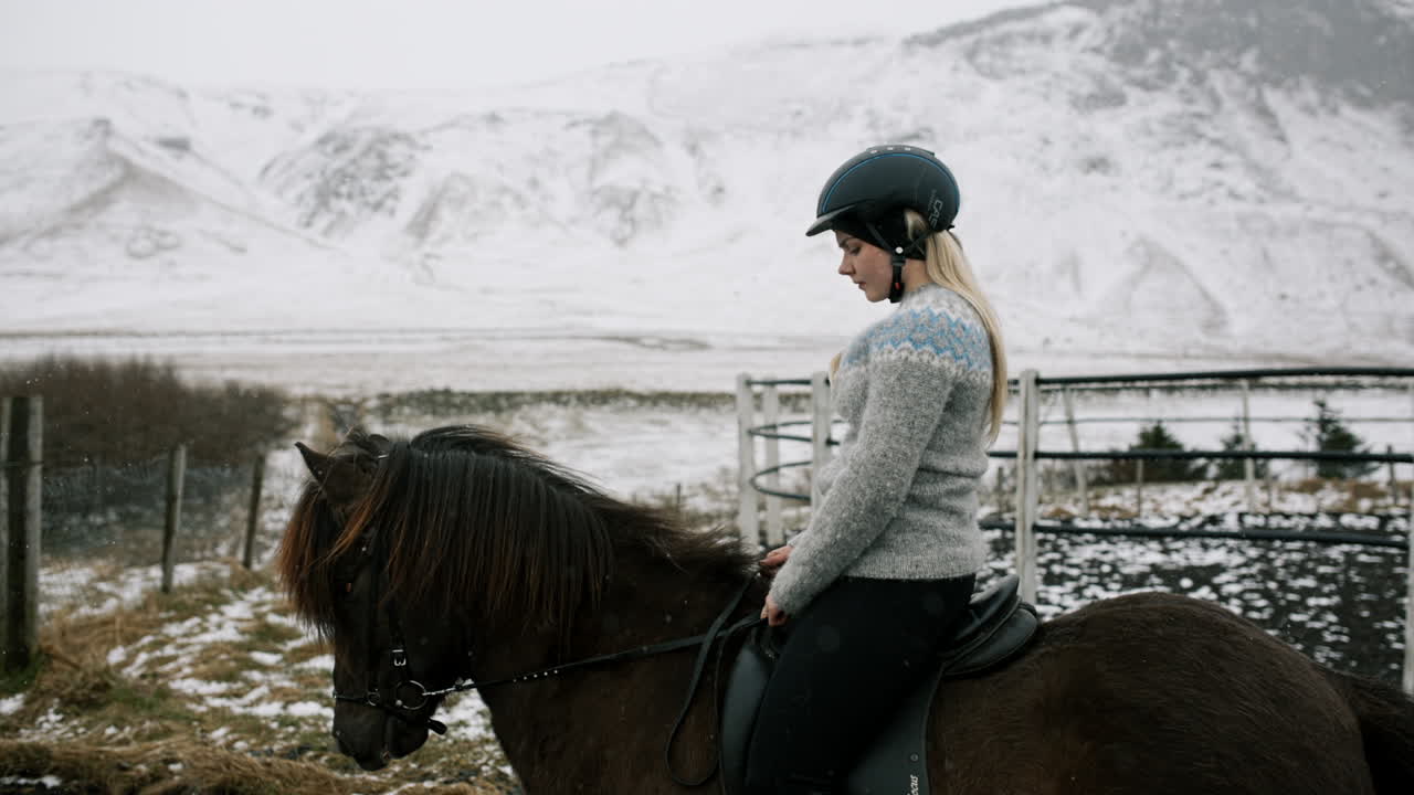 Woman horseback riding in snowy Icelandic landscape