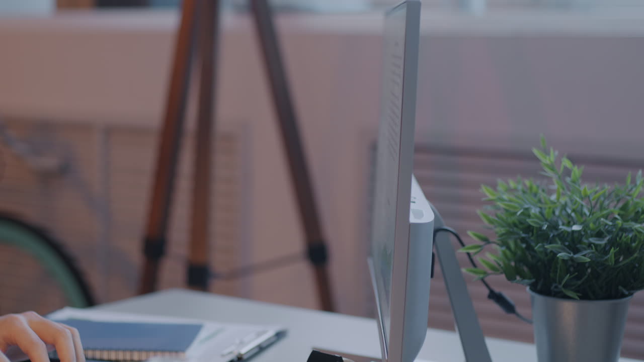 Person working at a desk with a computer monitor