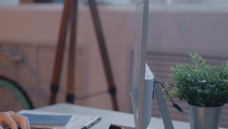 person working at a desk with a computer monitor