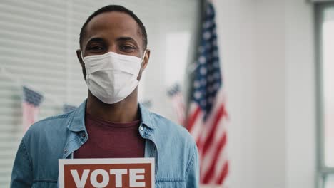 video of black man in face mask with voting card