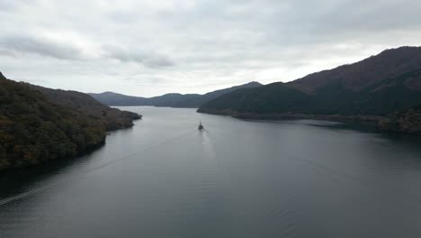 Amplia-Vista-Abierta-Sobre-El-Lago-Con-Un-Pequeño-Barco-En-Un-Día-Nublado.